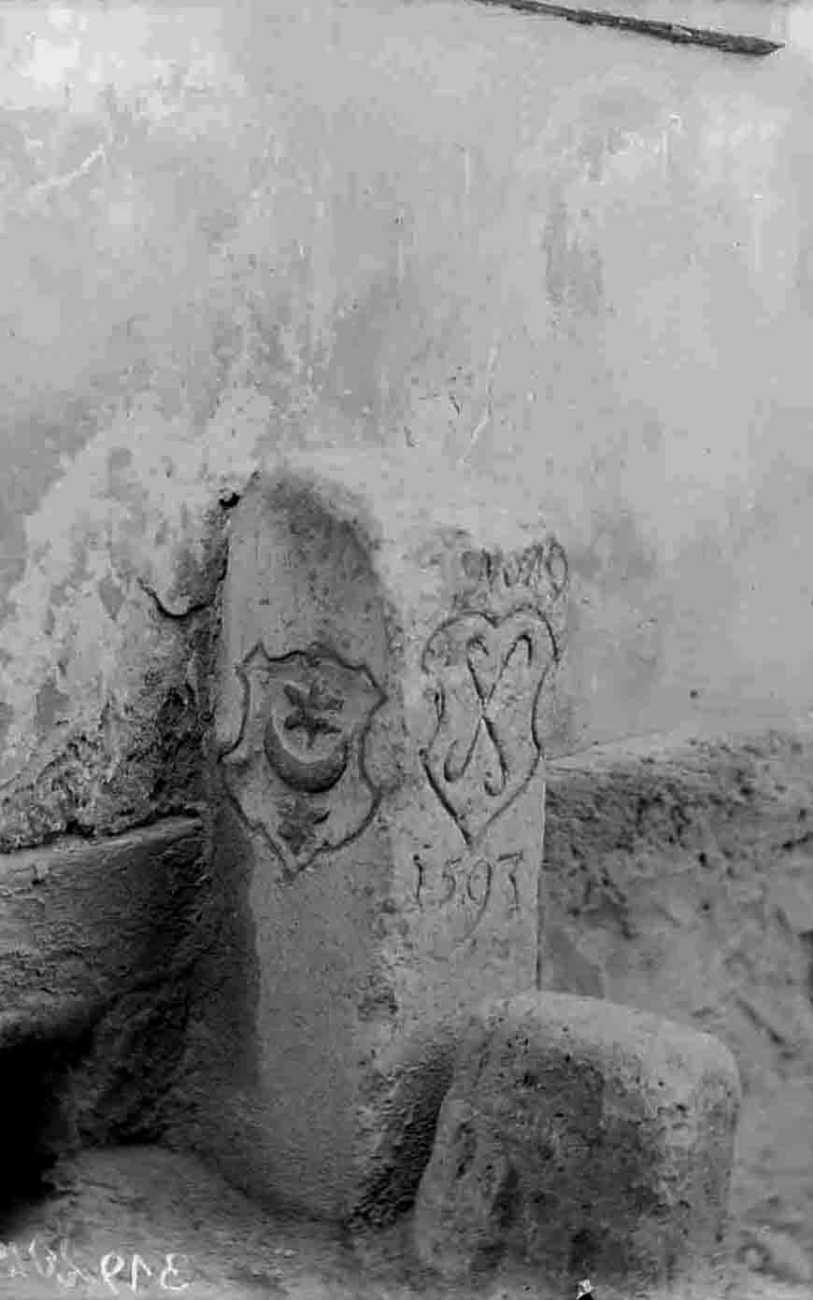 Ein Grenzstein mit den Wappen der Stadt Halle und des Salinebezirks sowie der eingravierten Jahreszahl 1593 steht an einer Hauswand.